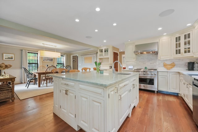 194 Josies Ring Rd, Monroe, CT 06468 - kitchen with a sink, stainless steel appliances, wall chimney exhaust hood, glass insert cabinets, and light wood-style floors