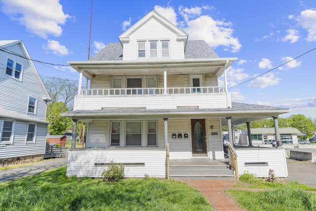 view of front facade with covered porch, a balcony, and a shingled roof