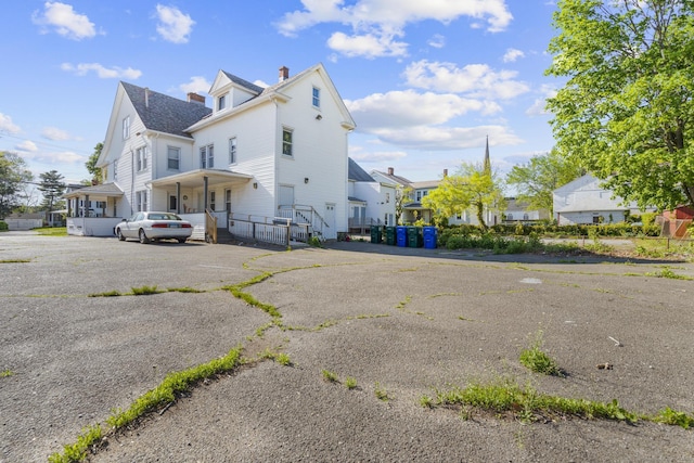 back of property featuring a chimney and a residential view