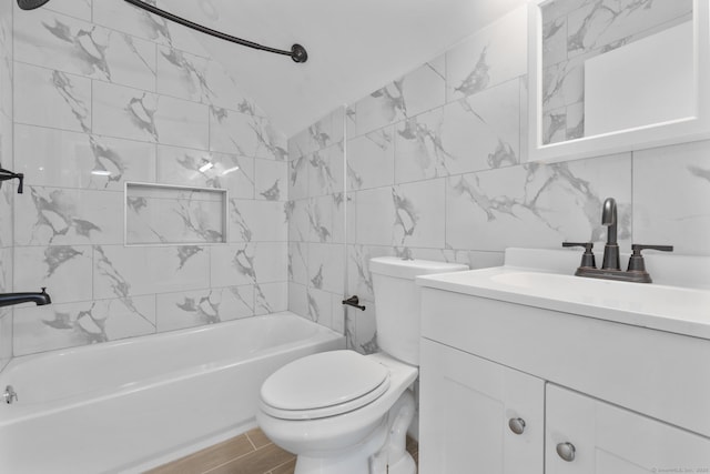bathroom featuring tile walls, vanity, toilet, bathtub / shower combination, and wood finished floors