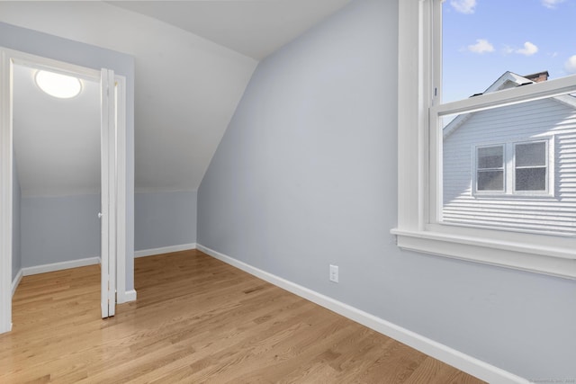 bonus room featuring lofted ceiling, baseboards, and light wood-type flooring