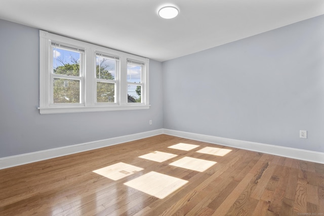 empty room featuring baseboards and wood finished floors