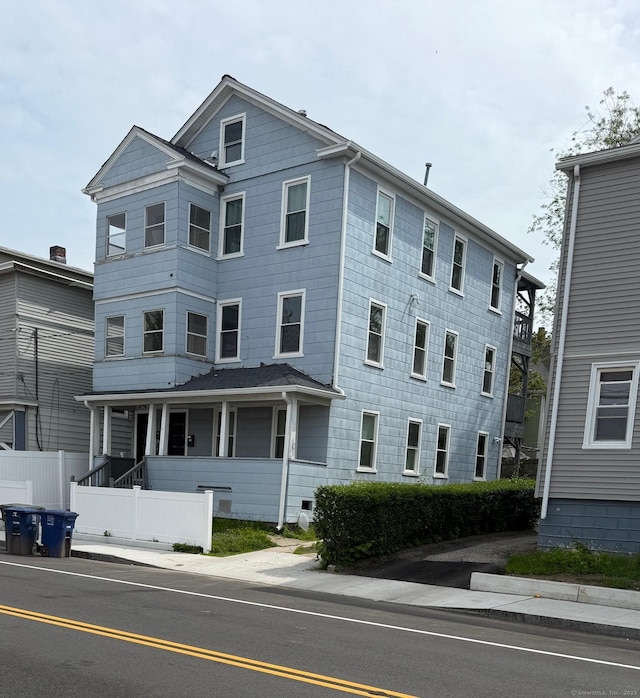 view of front facade featuring fence and covered porch