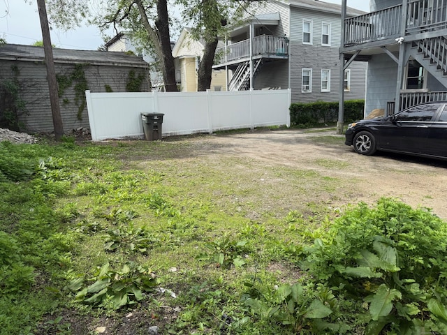 view of yard featuring fence and stairway