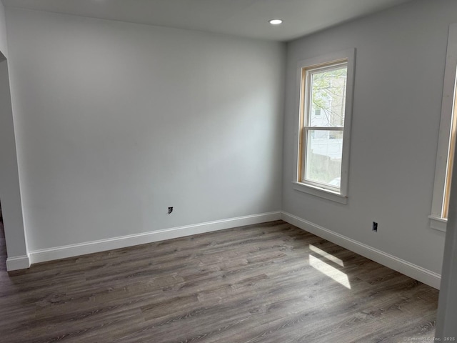 empty room featuring dark wood-style floors, baseboards, and recessed lighting
