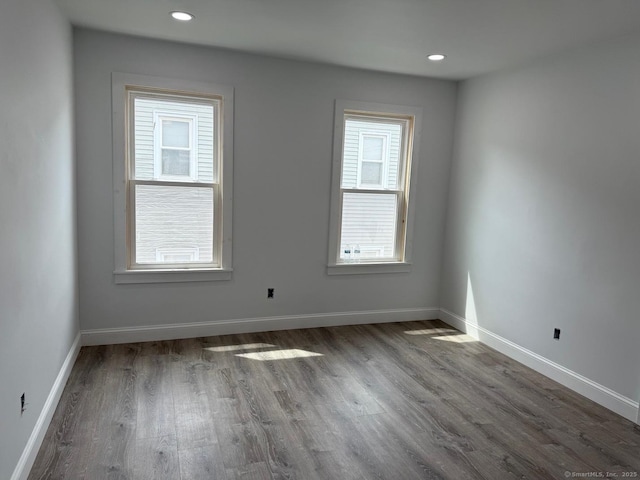 unfurnished room with wood finished floors, baseboards, and recessed lighting