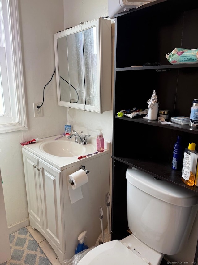 bathroom featuring toilet, vanity, and tile patterned floors