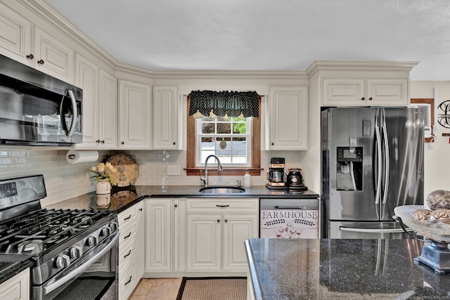 13 Carol St, Enfield, CT 06082 - kitchen featuring appliances with stainless steel finishes, tasteful backsplash, dark stone countertops, and light tile patterned flooring