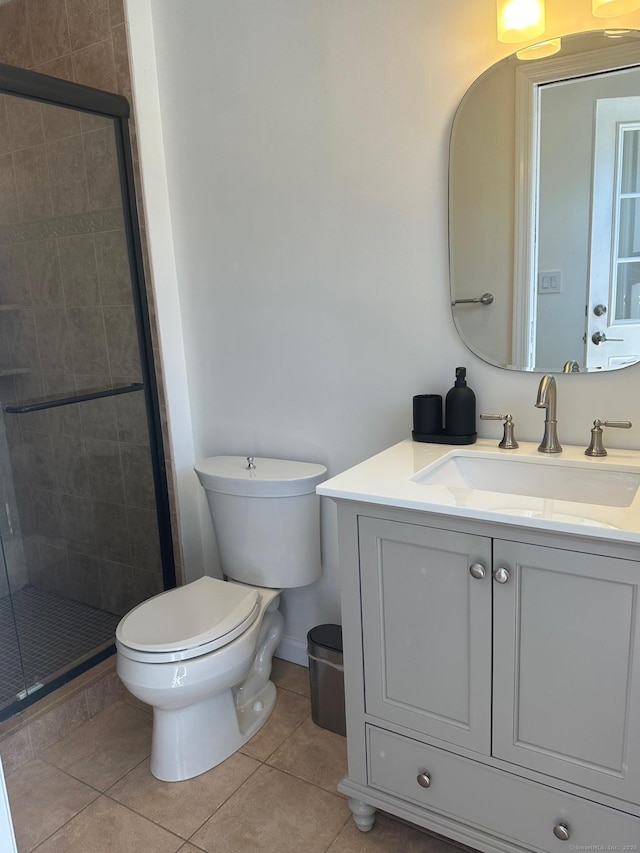 full bath featuring toilet, a shower stall, vanity, tile patterned flooring, and baseboards