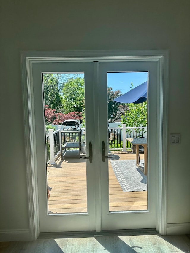 entryway featuring french doors, wood finished floors, and baseboards