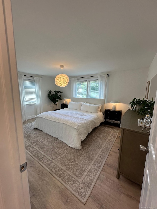 bedroom featuring wood finished floors and multiple windows