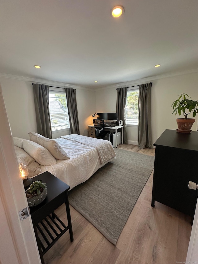 bedroom with multiple windows, light wood-type flooring, crown molding, an office area, and recessed lighting