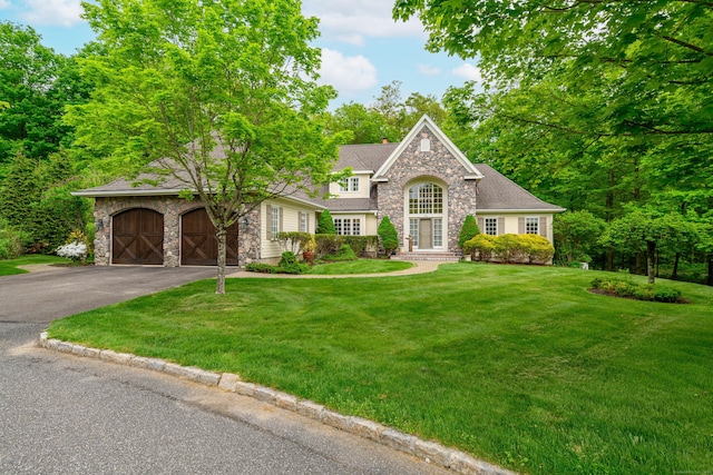 34 Avalon Dr, Middlebury, CT 06762 - traditional-style house featuring stone siding, driveway, a chimney, a front yard, and a garage