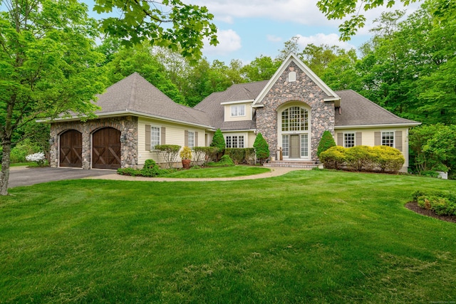 34 Avalon Dr, Middlebury, CT 06762 - traditional-style home featuring stone siding, a front lawn, driveway, and a garage