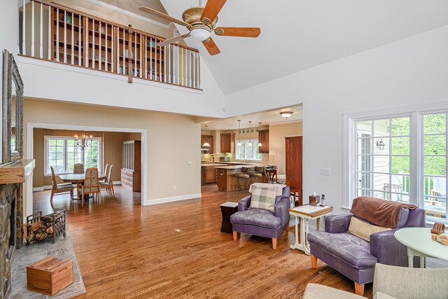 34 Avalon Dr, Middlebury, CT 06762 - living room featuring light wood-type flooring, a ceiling fan, a chandelier, baseboards, and high vaulted ceiling