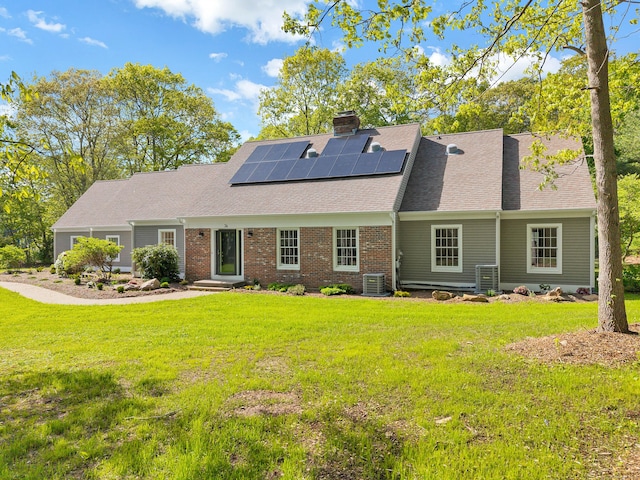 34 Willow Ln, East Lyme, CT 06333 - view of front of home with central AC, roof mounted solar panels, a front lawn, and a shingled roof