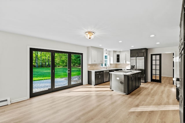 34 Willow Ln, East Lyme, CT 06333 - kitchen featuring appliances with stainless steel finishes, light countertops, backsplash, a sink, and light wood-type flooring
