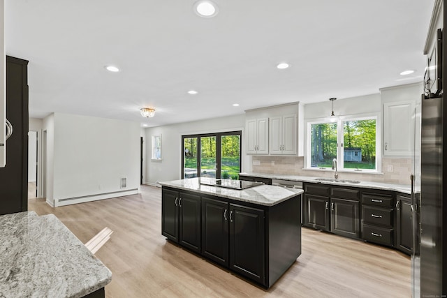 34 Willow Ln, East Lyme, CT 06333 - kitchen featuring a sink, a baseboard heating unit, stainless steel appliances, dark cabinetry, and decorative backsplash