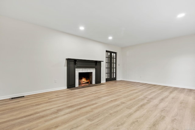 34 Willow Ln, East Lyme, CT 06333 - unfurnished living room with a fireplace with flush hearth, light wood-style floors, recessed lighting, and baseboards