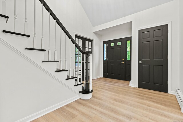 34 Willow Ln, East Lyme, CT 06333 - entryway featuring stairs, light wood-style floors, baseboards, high vaulted ceiling, and a baseboard heating unit
