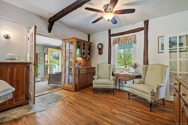 255 Killingly Rd, Pomfret, CT 06259 - sitting room featuring baseboard heating, wood finished floors, beam ceiling, a ceiling fan, and a baseboard radiator