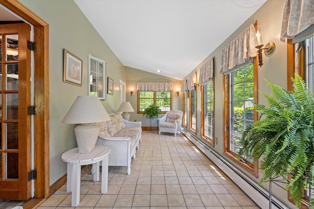 sunroom with a baseboard heating unit, lofted ceiling, tile patterned flooring, and baseboards