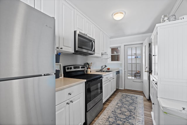 211 W Walk Unit 211, West Haven, CT 06516 - kitchen with appliances with stainless steel finishes, a sink, white cabinetry, light countertops, and ornamental molding
