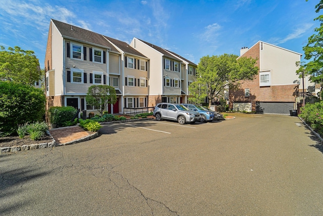 view of property featuring uncovered parking and a residential view