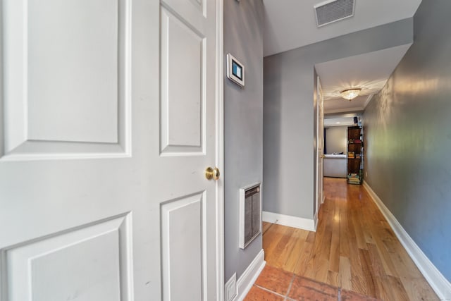 hallway featuring wood finished floors and baseboards