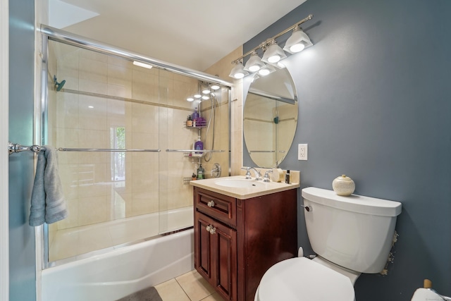 bathroom with toilet, vanity, tile patterned floors, and enclosed tub / shower combo