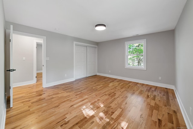 26 Maple Ave, North Haven, CT 06473 - unfurnished bedroom featuring light wood-type flooring, baseboards, and a closet