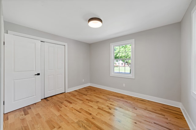 26 Maple Ave, North Haven, CT 06473 - unfurnished bedroom featuring light wood finished floors, baseboards, and a closet