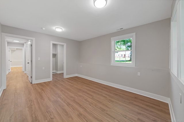 26 Maple Ave, North Haven, CT 06473 - unfurnished bedroom with light wood-type flooring, baseboards, a spacious closet, and a closet