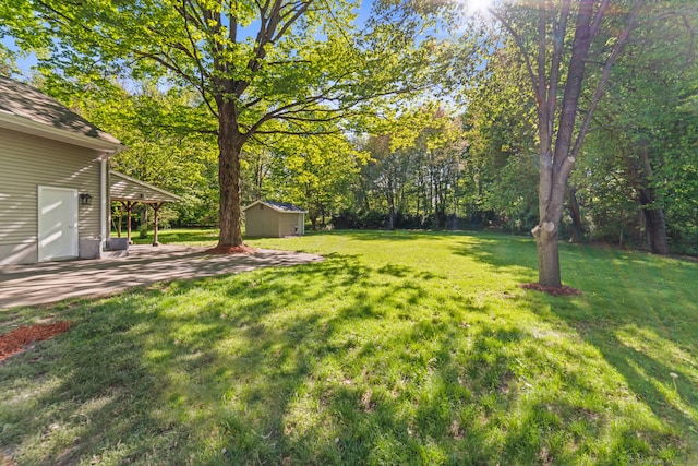 26 Maple Ave, North Haven, CT 06473 - view of grassy yard with a storage shed, an outdoor structure, a patio, and view of wooded area