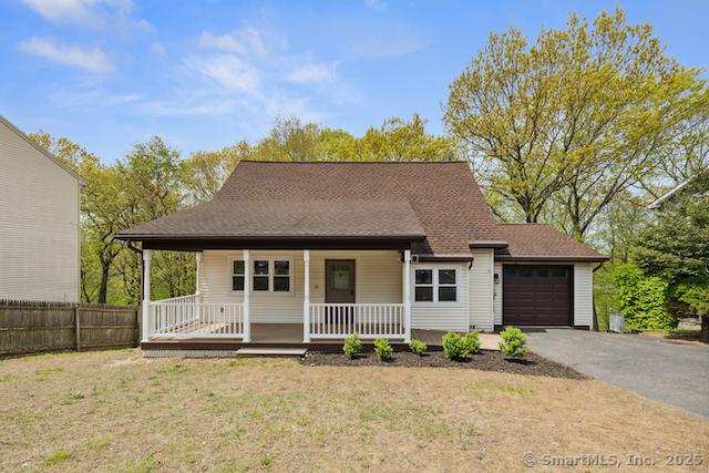 view of front of house with a porch, asphalt driveway, and a garage