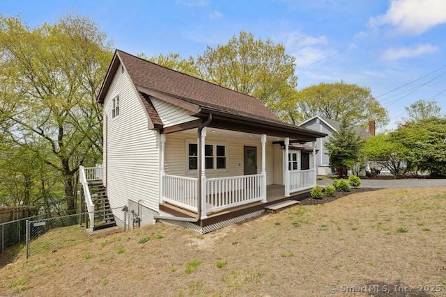 view of front of home featuring fence, a porch, and stairs