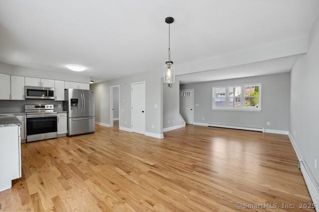 kitchen featuring stainless steel appliances, a baseboard radiator, white cabinets, and open floor plan