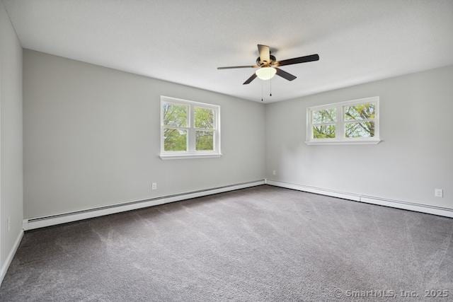 carpeted spare room featuring healthy amount of natural light, ceiling fan, a baseboard heating unit, and baseboards