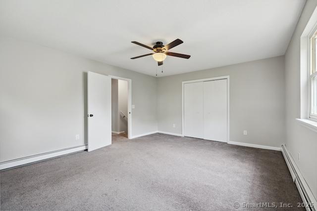 unfurnished bedroom with a baseboard radiator, carpet, a closet, a ceiling fan, and baseboards