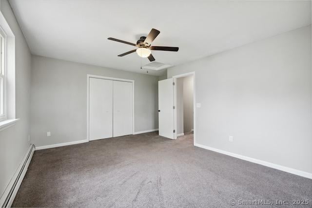 unfurnished bedroom featuring baseboard heating, carpet floors, and baseboards