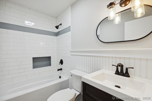 full bathroom with wainscoting, toilet, washtub / shower combination, and vanity