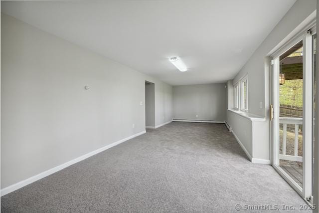 carpeted empty room featuring baseboards