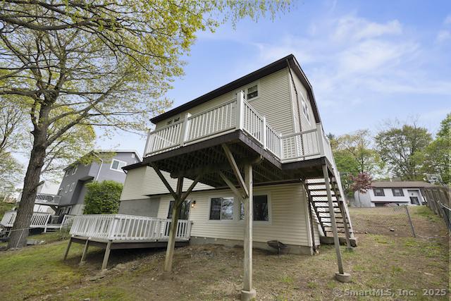 back of property with a deck and stairs