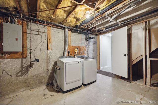 unfinished below grade area with electric panel and washer and clothes dryer