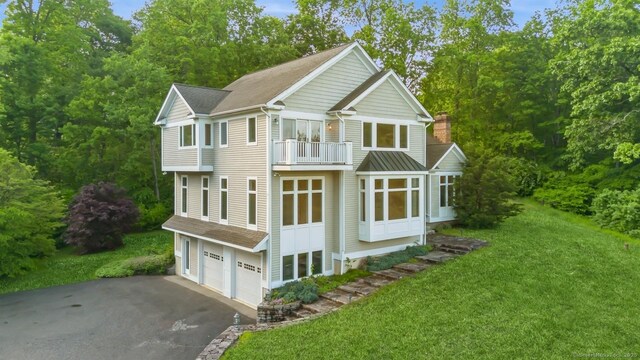 65 Church Rd, Sherman, CT 06784 - view of front of house with a balcony, asphalt driveway, an attached garage, a front yard, and a chimney