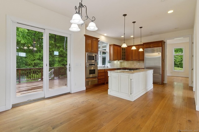 65 Church Rd, Sherman, CT 06784 - kitchen featuring built in appliances, a warming drawer, brown cabinets, backsplash, and light wood finished floors
