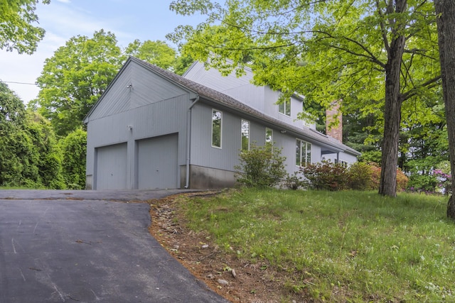 2 Meadowview Ln, Norwich, CT 06360 - view of property exterior with asphalt driveway, a garage, and a chimney