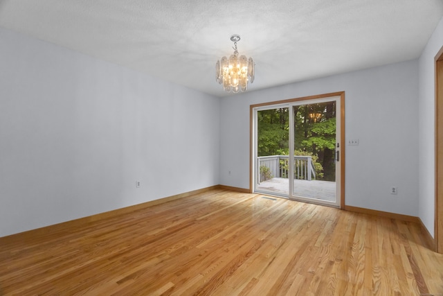2 Meadowview Ln, Norwich, CT 06360 - spare room featuring a chandelier, light wood-style floors, and baseboards