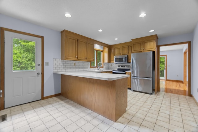 2 Meadowview Ln, Norwich, CT 06360 - kitchen with appliances with stainless steel finishes, a peninsula, plenty of natural light, decorative backsplash, and recessed lighting