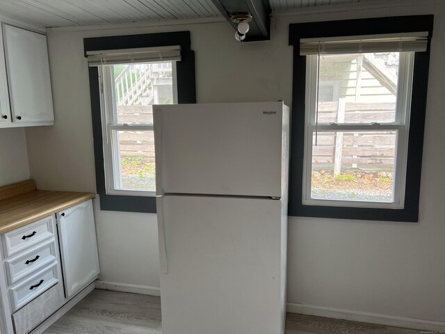 24 New St, Seymour, CT 06483 - kitchen featuring freestanding refrigerator, white cabinetry, light wood-style floors, and light countertops